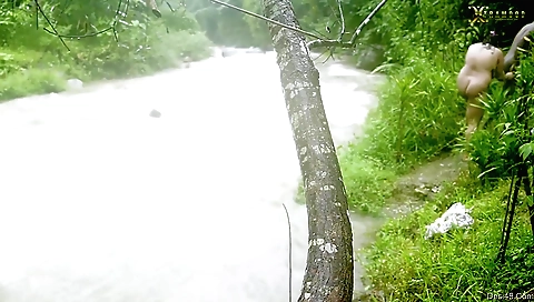 Beautiful girl with a big booty in the river is stretched out